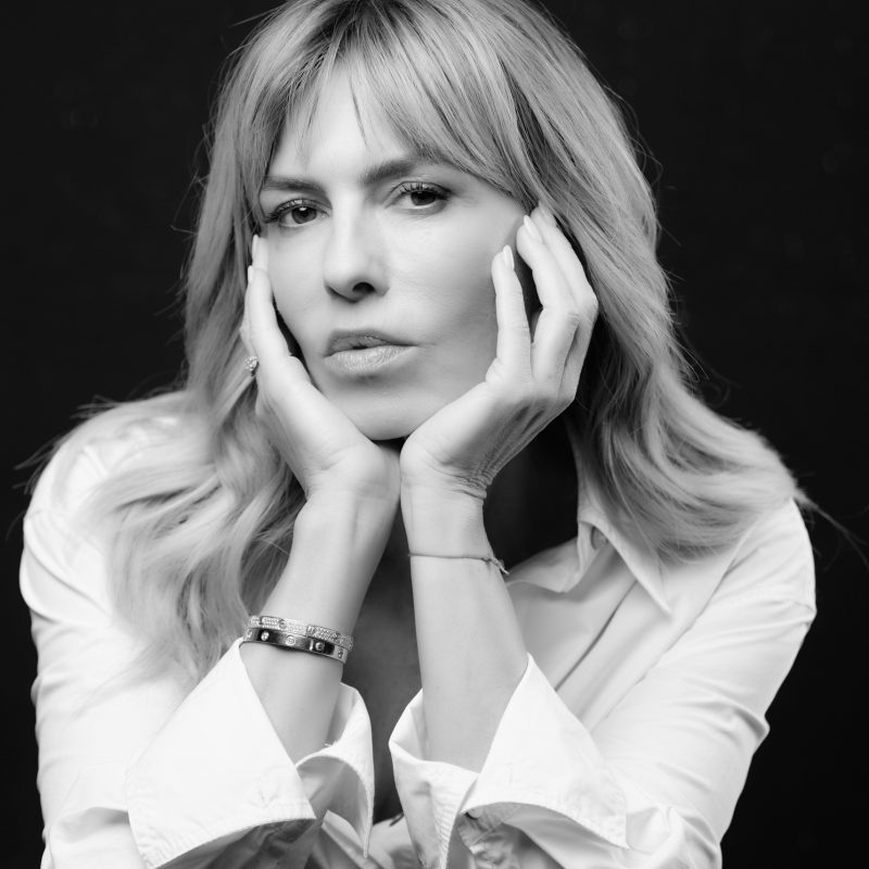 Esther Sarphatie in a black-and-white portrait, hands on cheeks, wearing a white shirt.